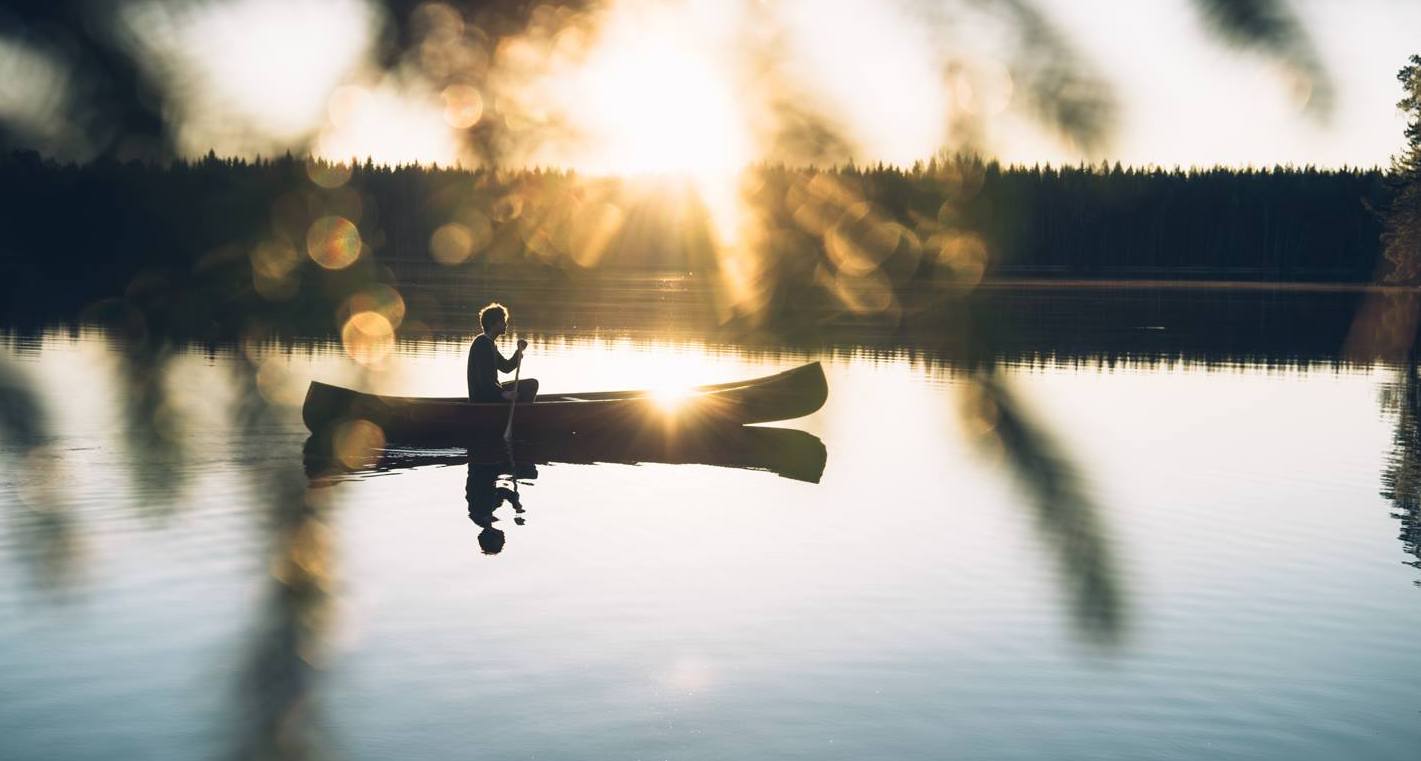 A man rowing a boat on a lake at sunset. Image by Eerikkilä Sports & Outdoor.